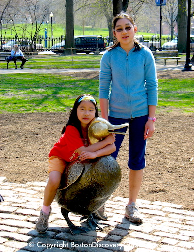 Children posing by Make Way for Ducklings statues in Boston's Public Garden