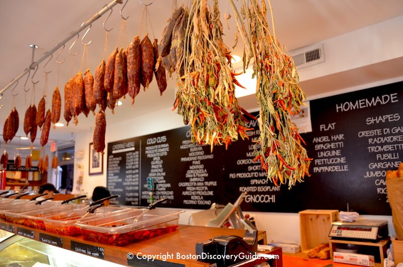Sausages and chilis hanging over the meat counter n Bricco Salumeria in Boston's North End